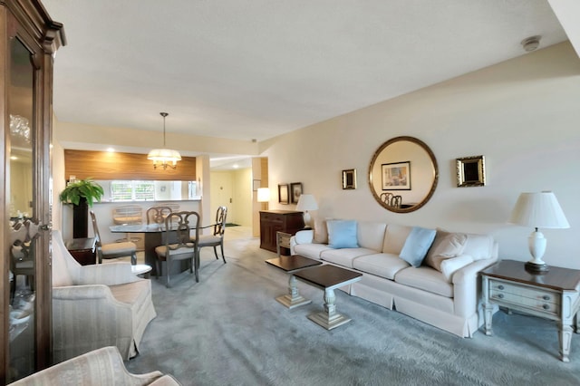 carpeted living room with a chandelier