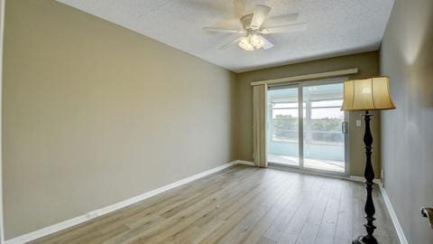 empty room featuring ceiling fan, light hardwood / wood-style flooring, and a textured ceiling