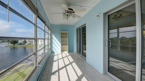 unfurnished sunroom featuring ceiling fan, a healthy amount of sunlight, and a water view