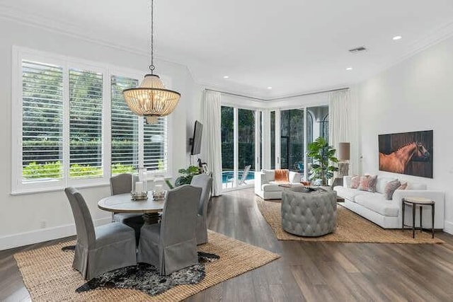 dining space with hardwood / wood-style flooring, ornamental molding, and a chandelier