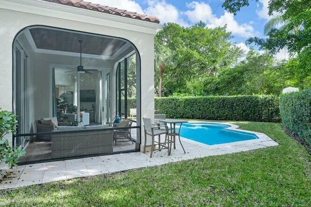 view of pool with outdoor lounge area, a yard, a patio, and ceiling fan