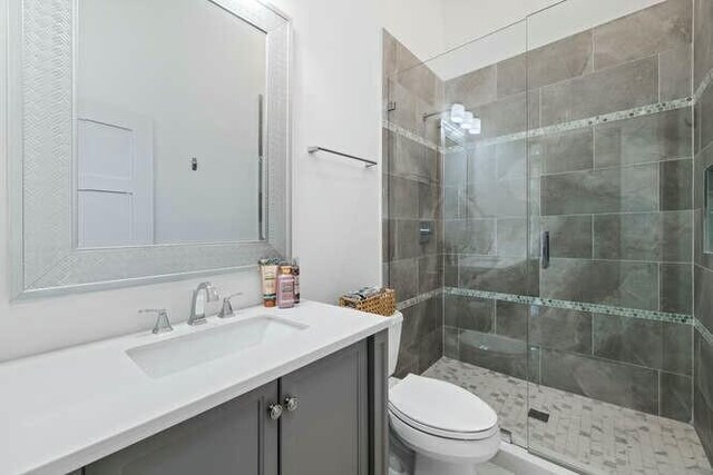 bathroom featuring an enclosed shower, vanity, and toilet