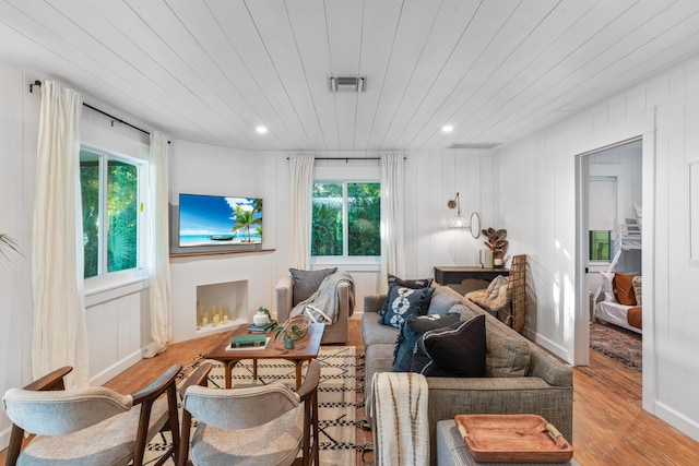 living room with wooden ceiling, light hardwood / wood-style flooring, and a healthy amount of sunlight