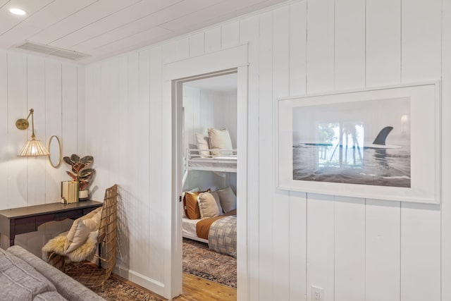 interior space with hardwood / wood-style flooring and wood walls