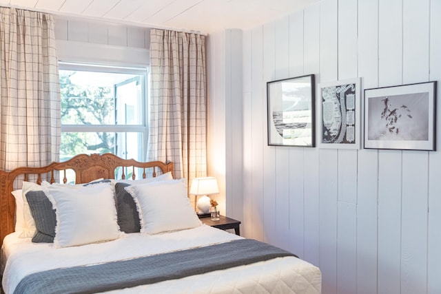 bedroom featuring wooden walls