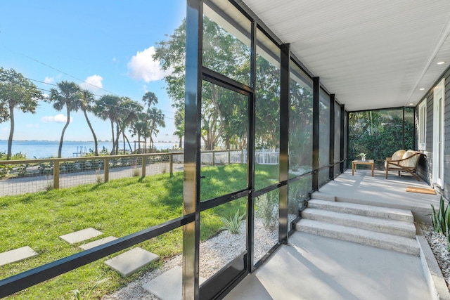 sunroom featuring a water view