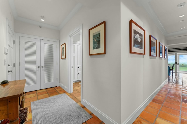 corridor with light tile patterned floors and crown molding