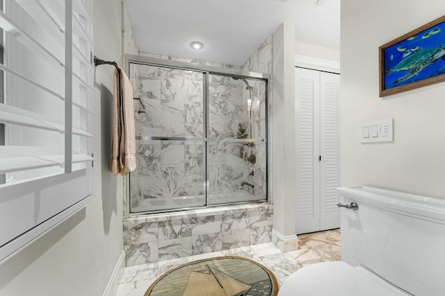 bathroom featuring bath / shower combo with glass door and toilet