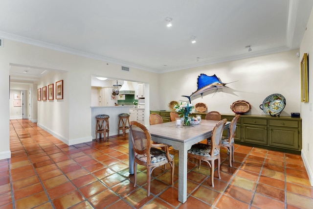 dining area with tile patterned flooring and crown molding