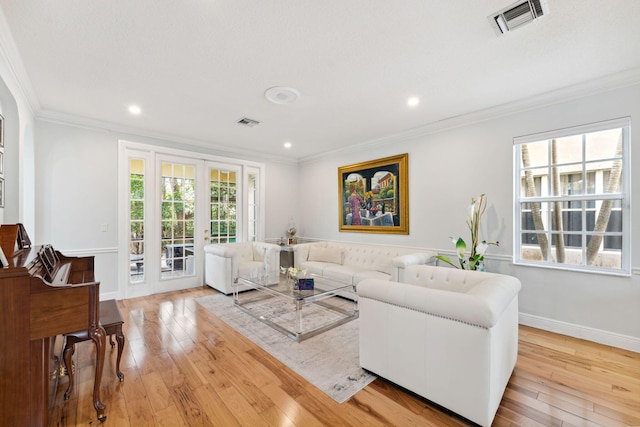 living room with light wood-type flooring, french doors, and crown molding