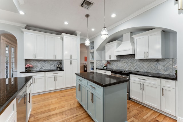 kitchen with decorative light fixtures, white cabinets, tasteful backsplash, and custom range hood