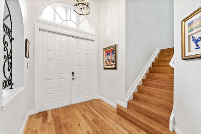 entryway with light wood-type flooring and a chandelier