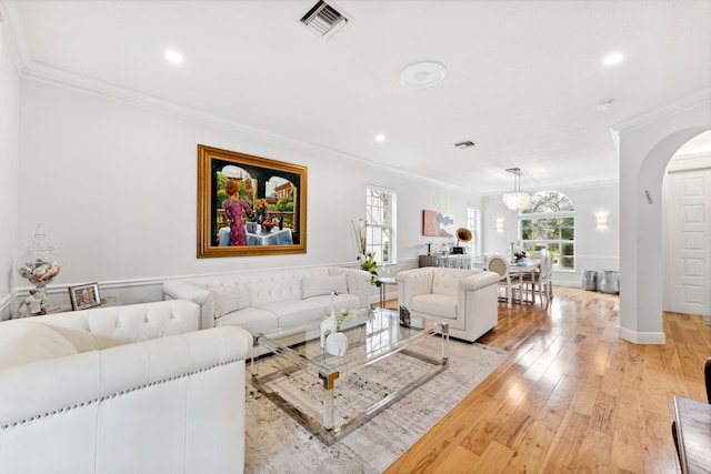 living room featuring crown molding, light hardwood / wood-style flooring, and plenty of natural light