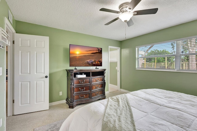 bedroom with ceiling fan and a textured ceiling