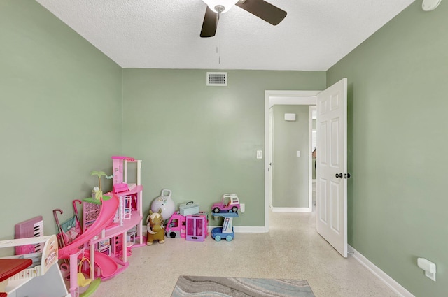 game room featuring ceiling fan and a textured ceiling