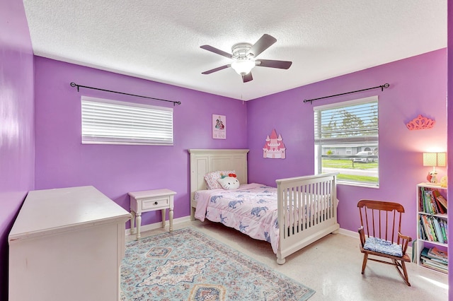 bedroom with ceiling fan and a textured ceiling