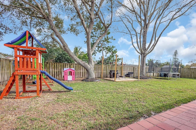 view of play area with a patio area, a trampoline, and a lawn