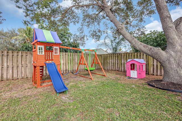 back of house featuring a lawn, a patio area, and a playground