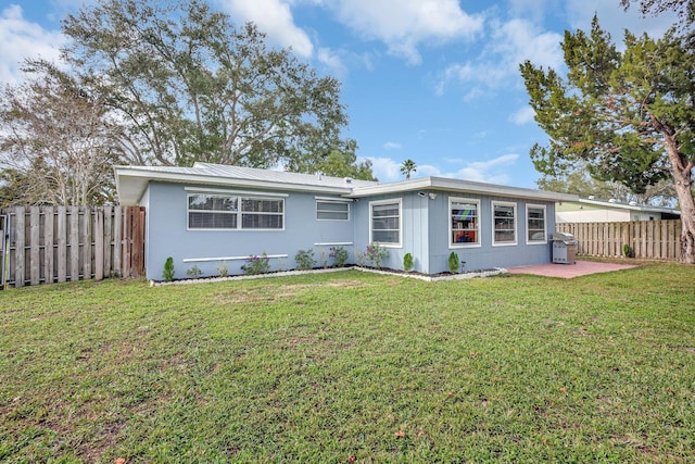 back of property featuring a patio area and a lawn