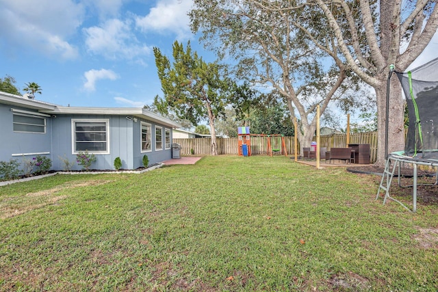 view of yard with a trampoline, a patio, and a playground