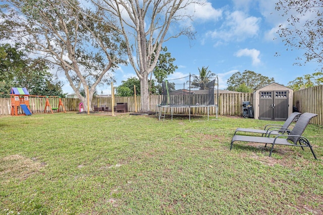 view of yard featuring a playground, a trampoline, and a shed