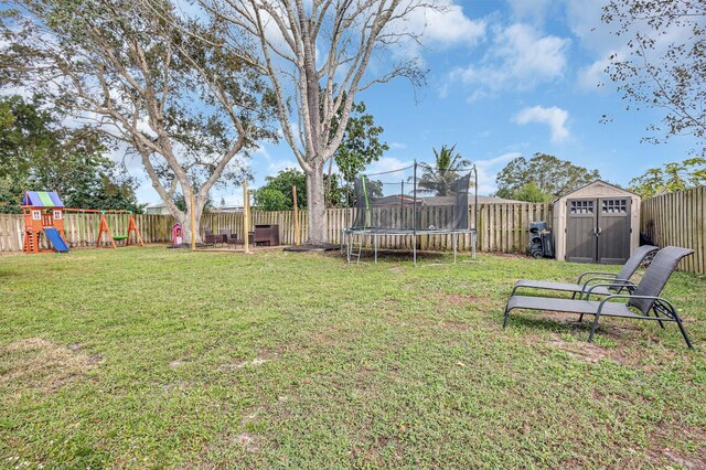 view of yard with a playground, a trampoline, and a shed