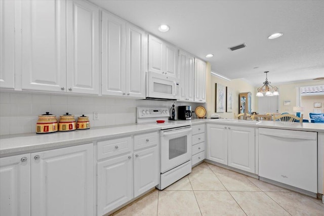 kitchen with white cabinetry, decorative light fixtures, light tile patterned floors, a notable chandelier, and white appliances