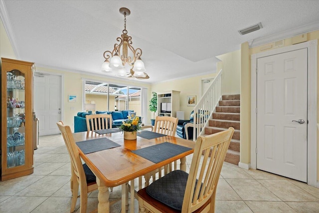 tiled dining room with crown molding, a textured ceiling, and a notable chandelier