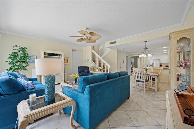 living room featuring crown molding, ceiling fan with notable chandelier, light tile patterned flooring, and a textured ceiling