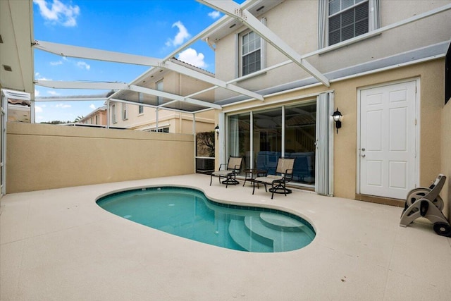 view of pool featuring a patio and glass enclosure