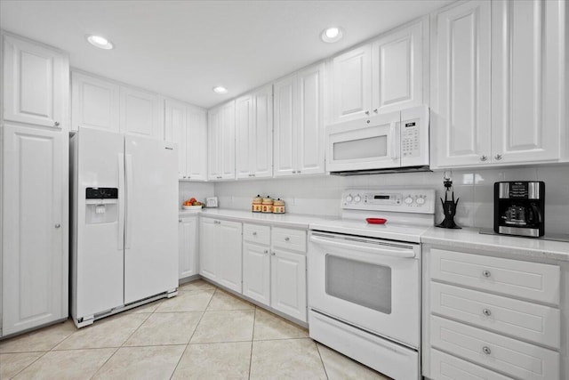 kitchen with light tile patterned floors, white appliances, and white cabinets