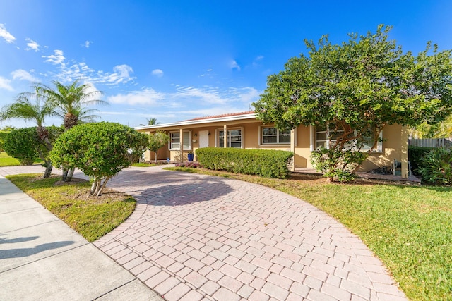 ranch-style home featuring a front lawn and covered porch