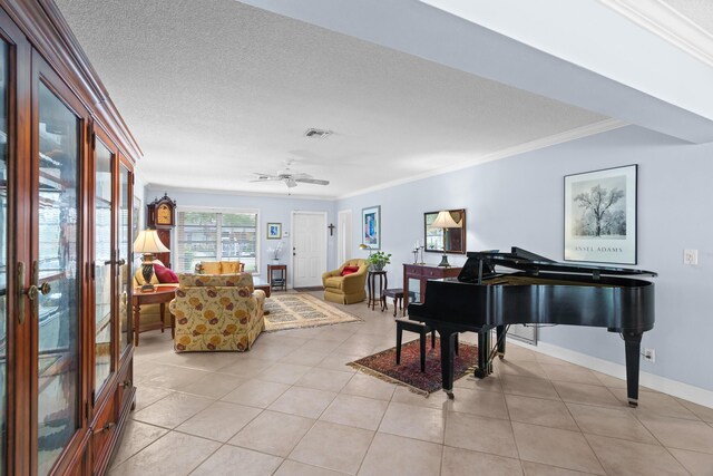 tiled living room with a textured ceiling, ceiling fan, and crown molding