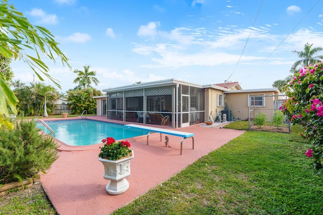 view of swimming pool featuring a sunroom, central AC unit, a patio area, and a yard