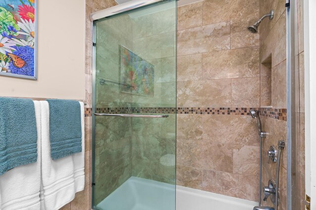 bathroom with vanity, toilet, a shower with door, and tile walls