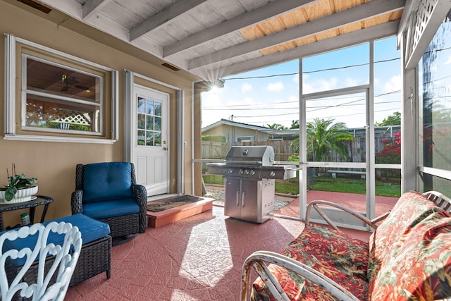 sunroom / solarium featuring lofted ceiling with beams, wood ceiling, and a healthy amount of sunlight