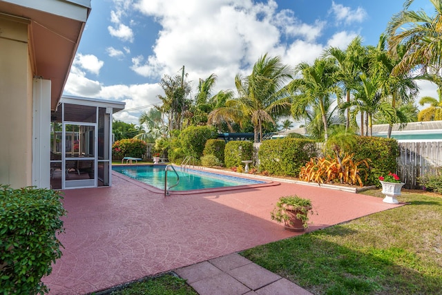 view of swimming pool with a patio, fence, a sunroom, and a fenced in pool