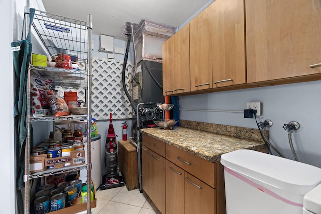 kitchen featuring brown cabinetry, light countertops, and light tile patterned floors