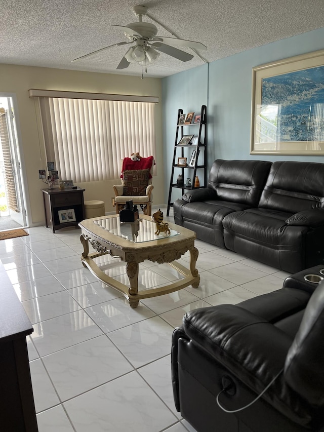 living room with ceiling fan, light tile patterned floors, and a textured ceiling