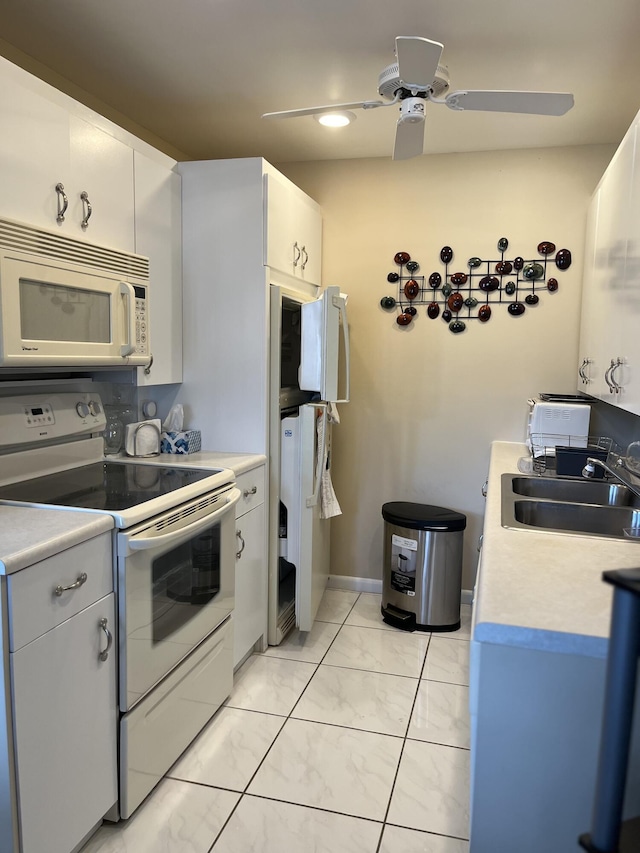 kitchen featuring white appliances, ceiling fan, sink, light tile patterned floors, and white cabinets