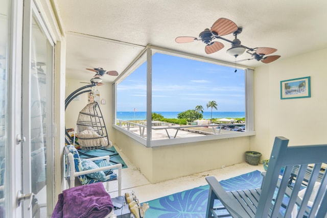 interior space with ceiling fan and a water view