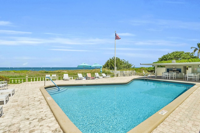 view of pool featuring a water view and a patio area