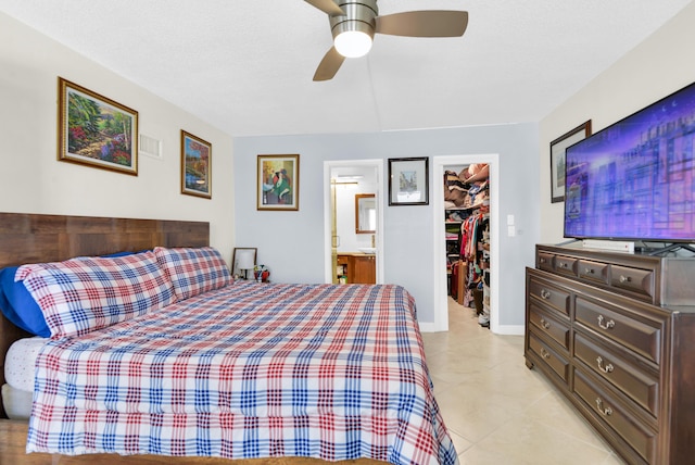 bedroom with ensuite bath, a spacious closet, a closet, and ceiling fan