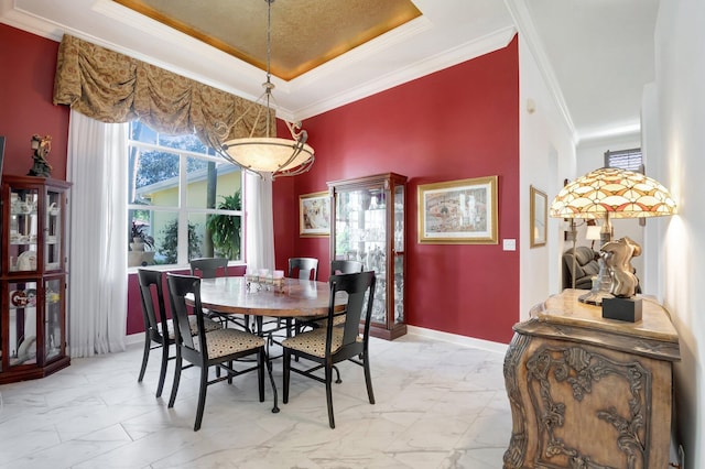 dining room with a tray ceiling and ornamental molding