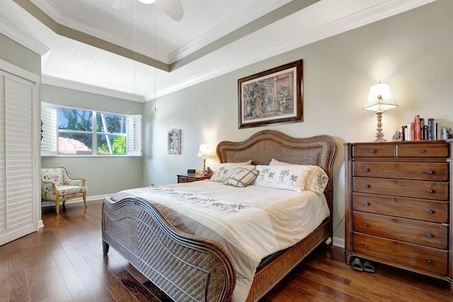 bedroom featuring dark hardwood / wood-style flooring, a raised ceiling, ceiling fan, and crown molding