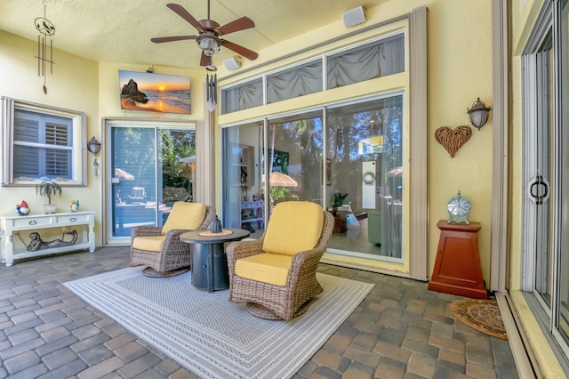 sunroom / solarium featuring ceiling fan