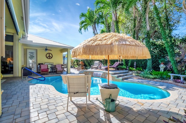 view of swimming pool with pool water feature, ceiling fan, and a patio