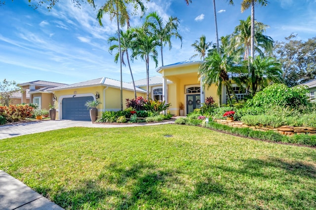 view of front of property with a front yard and a garage