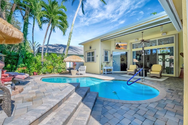 view of pool featuring ceiling fan, a mountain view, and a patio