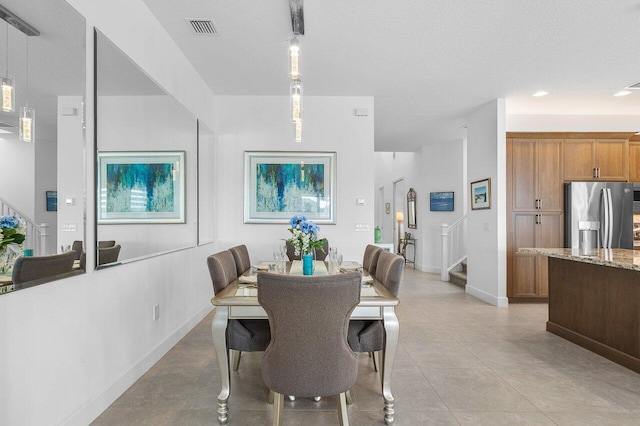 tiled dining room featuring a textured ceiling